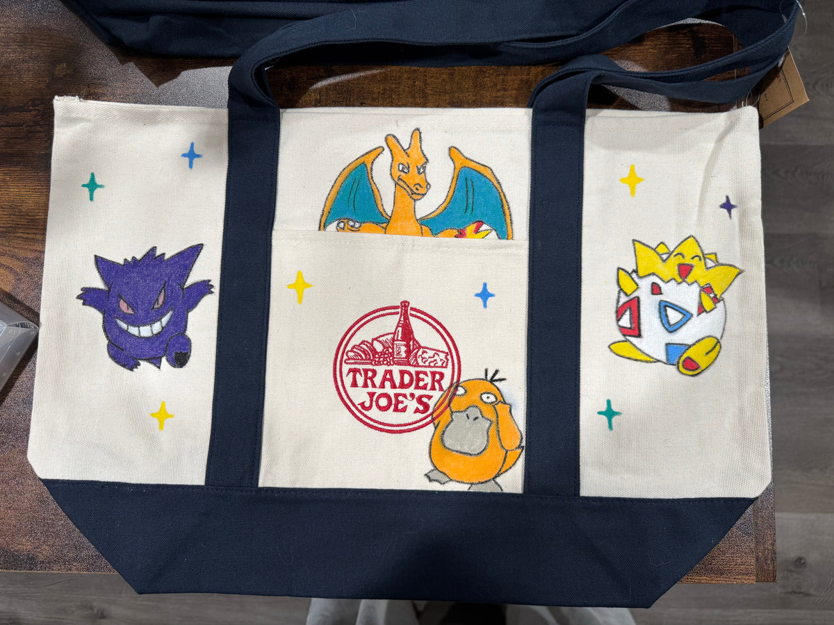 Back of Pocket Monsters hand painted tote with a fire dragon, a grinning ghost, a spiky egg baby, and a duck