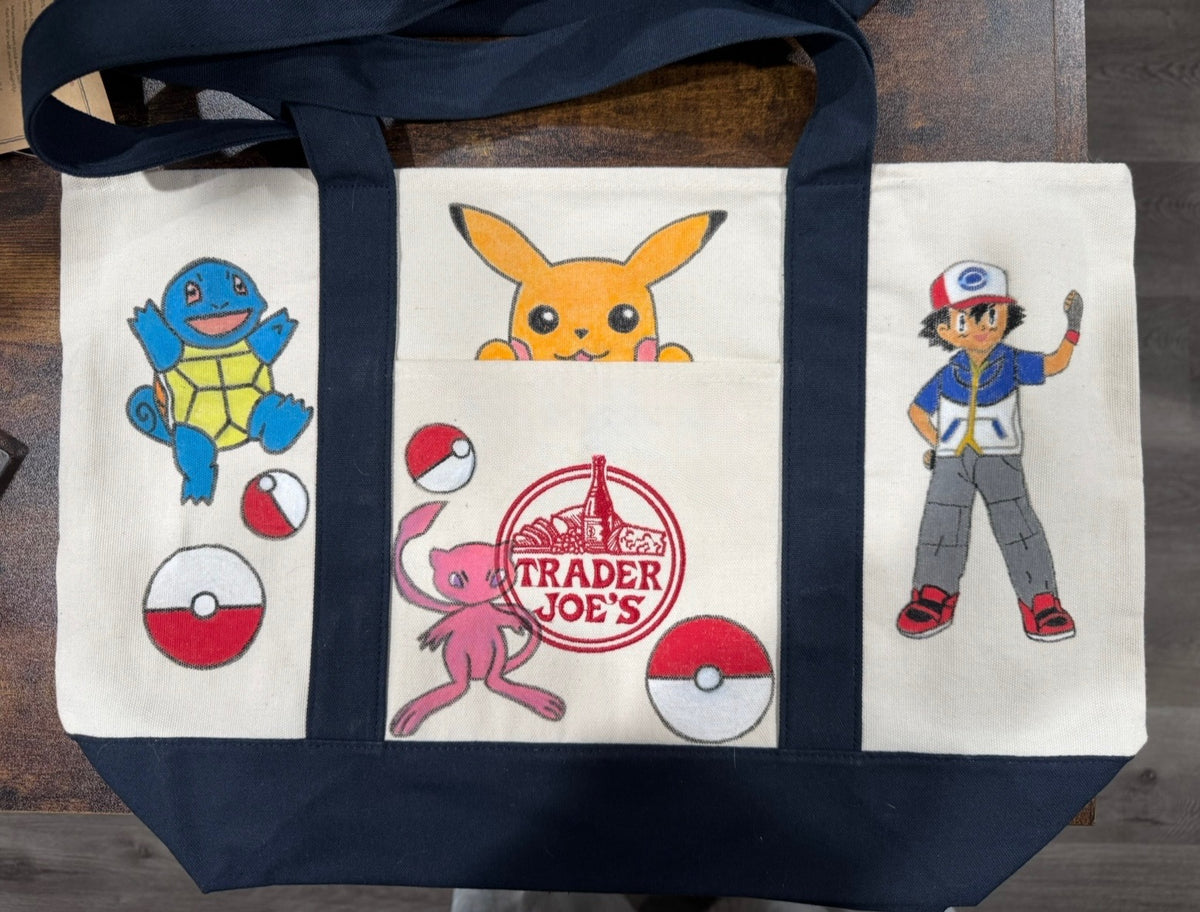 Pocket Monsters hand painted tote with an electric mouse peeking from the pocket, a water turtle, and a trainer
