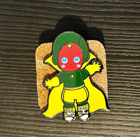Visionary Suburban Husband chibi enamel pin with green suit and yellow cape on a cork board